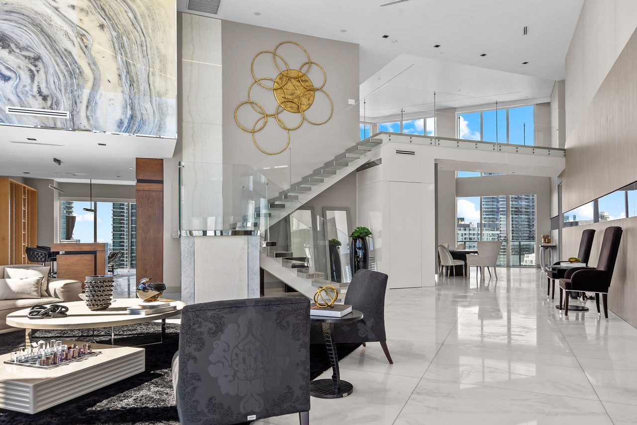 A floating glass staircase joins the two levels