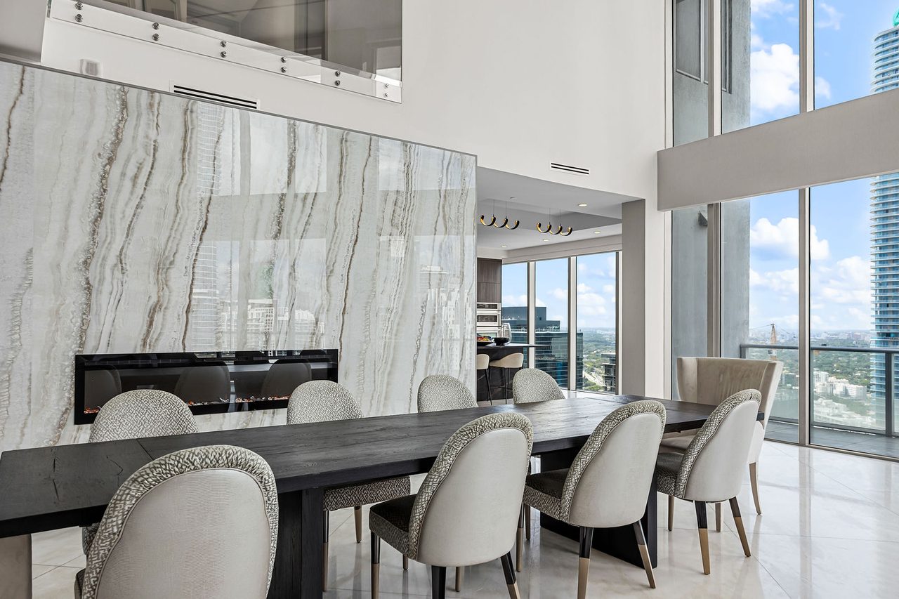 The dining room, with a fireplace set into a book-matched stone wall