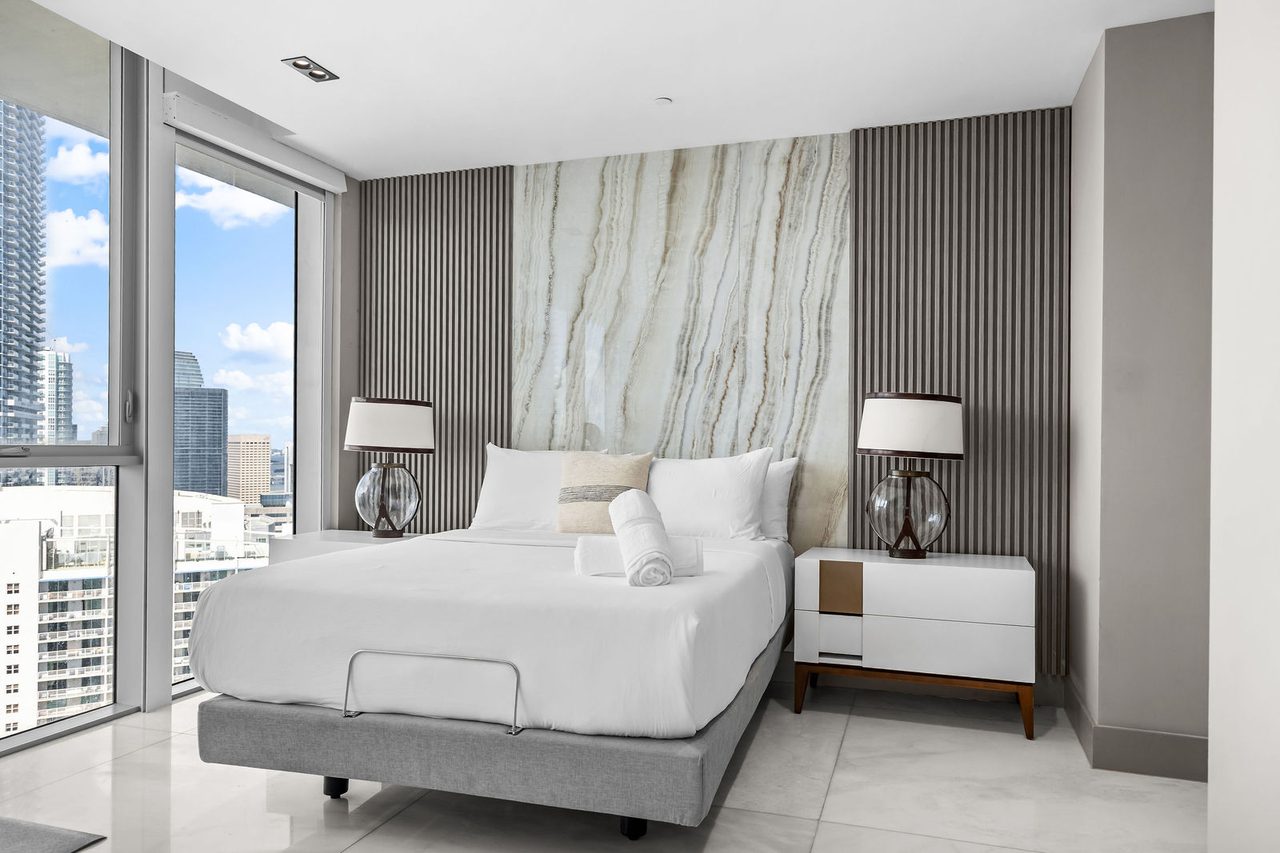 A guest bedroom with a stone headboard wall