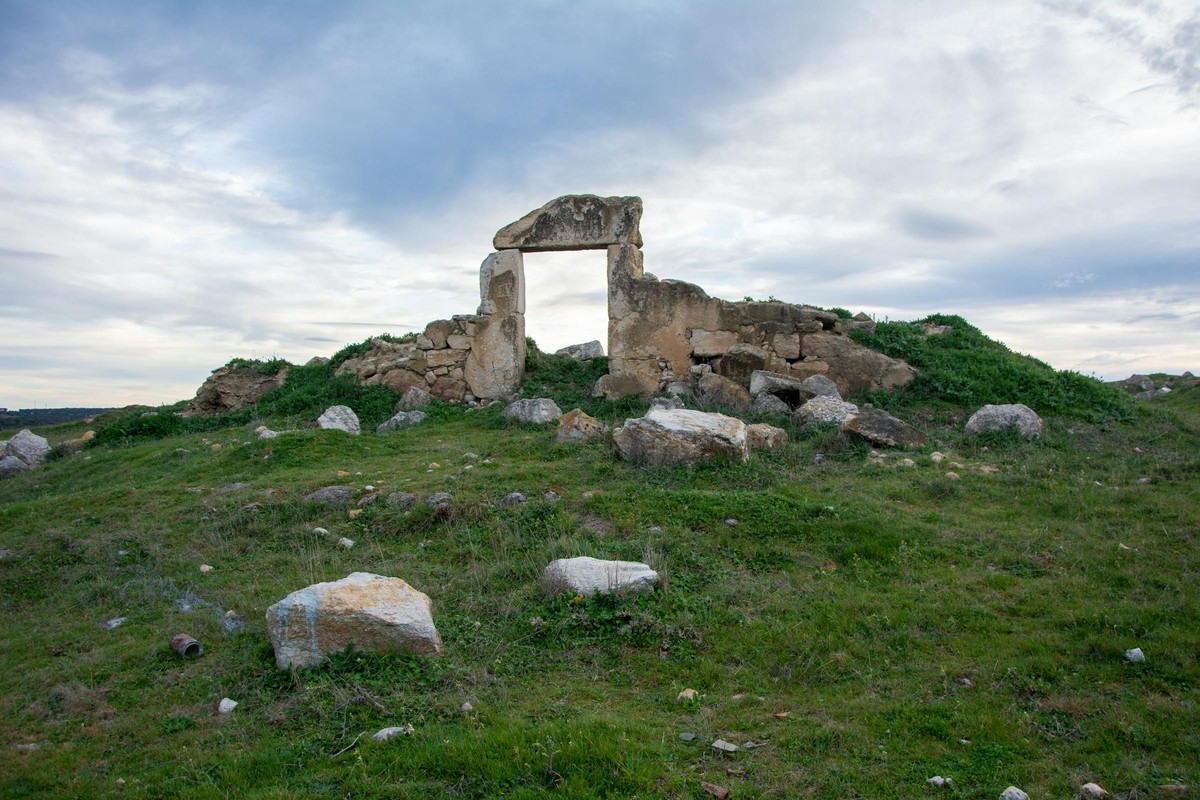 Nuraghi ruins at dawn with an archaeologist