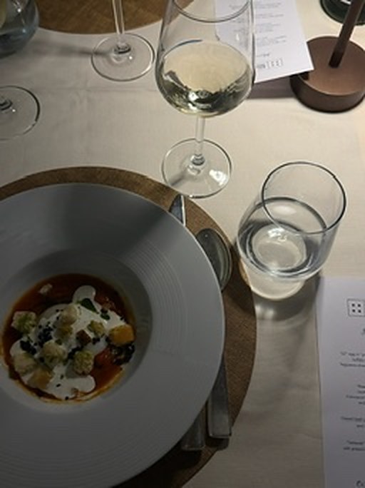 A plated dish and white wine at one of the trip's dinners